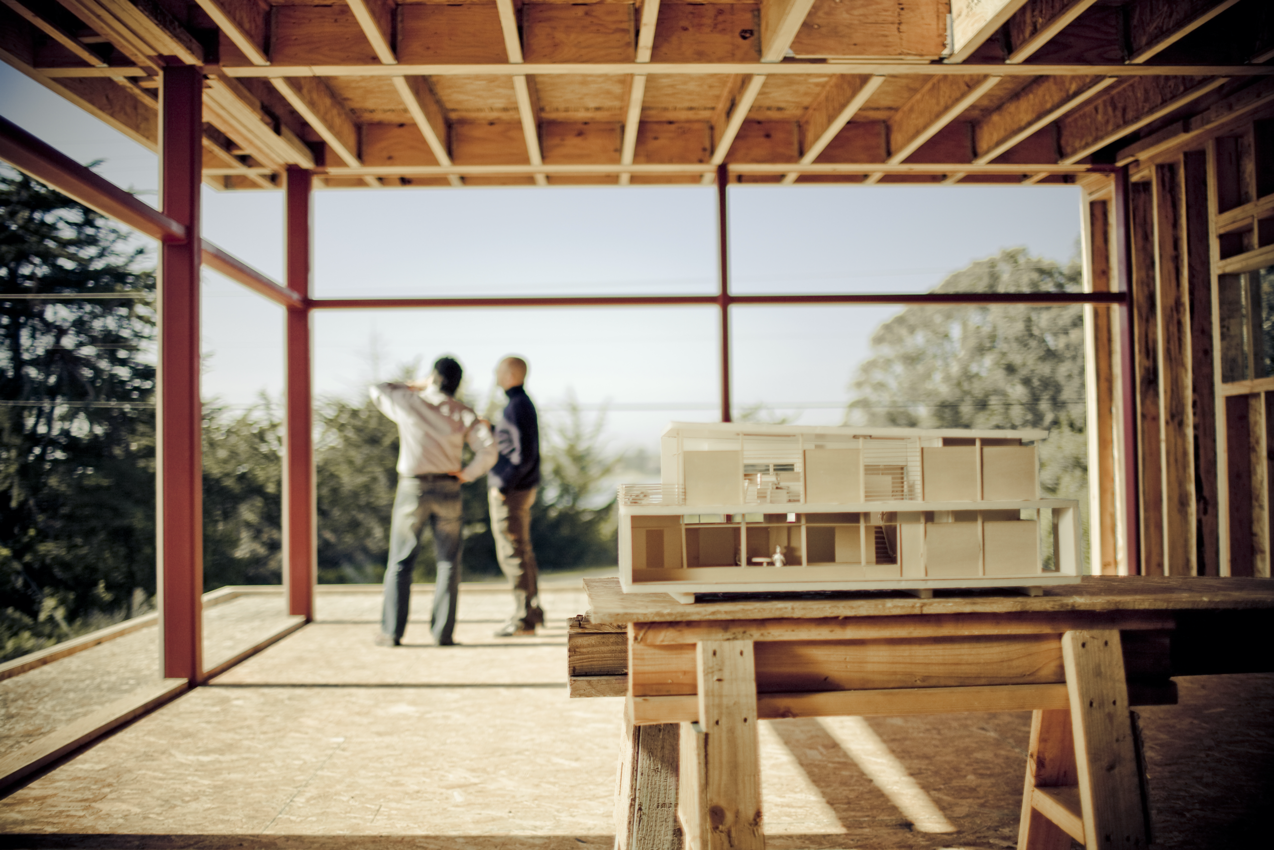 two men talking in a building being built